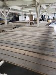 Stained wood boards staged and ready for final finishing. Rows of stained wood boards laid out inside a professional wood finishing facility before sealing and final coating.