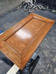 Custom cabinet door featuring a rich stained finish and smooth protective coating. Custom wood cabinet door finished with a rich stained wood coating by Leone’s Custom Coatings.