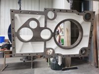 Large industrial steel component finished with a high-performance protective coating by Leone’s Custom Coatings. Large industrial steel plate with precision-applied protective coating, suspended during finishing at Leone’s Custom Coatings in Traverse City, Michigan.